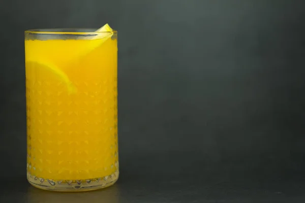 Jus d'orange dans le verre sur fond sombre — Photo