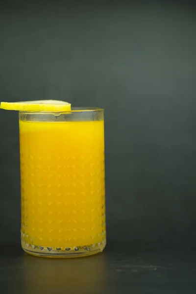 濃い背景にガラスのオレンジジュース — ストック写真