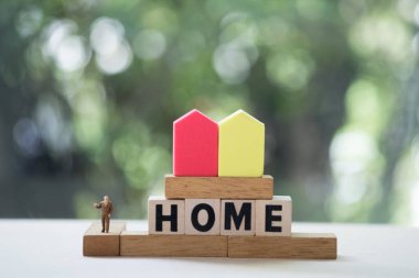 Minyatür insanlar Ev ahşap blok kelimeleri ile standı.