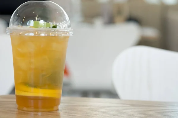 Kunststof glas thee limonade op houten tafel — Stockfoto