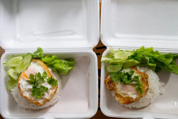 Telur goreng ditaruh di atas nasi putih dalam kotak busa. Dua kotak — Stok Foto
