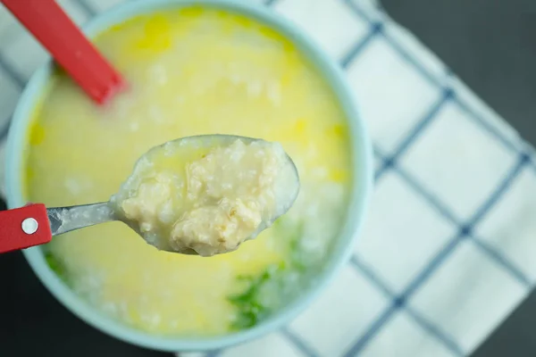 Comer mistura de mingau de arroz com ovo cru com carne de porco picada. Mingau de arroz ou prato de congee pela manhã — Fotografia de Stock