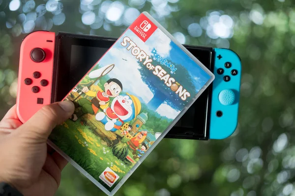 Bangkok, thailand - 11. oktober 2019. nintendo switch, die videospielkonsole für zuhause oder portable spiele und spiel doraemon geschichte der jahreszeiten. Das Spiel kombiniert die landwirtschaftlichen Simulationselemente aus der Geschichte von Staffeln und dem bekannten Dornröschenschlaf — Stockfoto