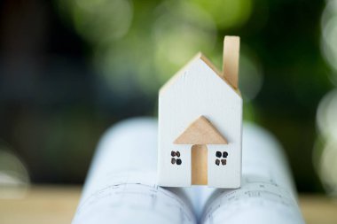 Kağıda sarılmış minyatür ahşap ev bina planları ve teknik çizimler. Ev konsepti projeleri