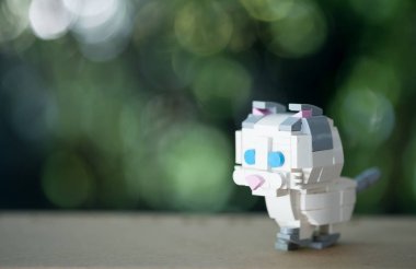 Tahta masada duran plastik oyuncak kedi.