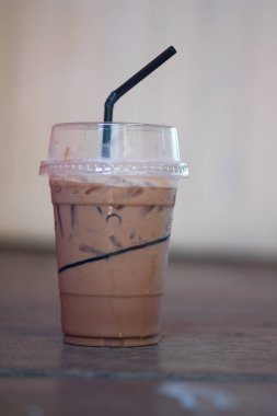 Ahşap masada plastik bardakta buzlu Mocha kahvesi.