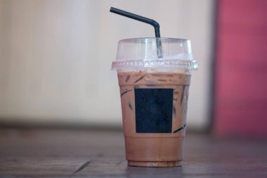 Ahşap masada plastik bardakta buzlu Mocha kahvesi.