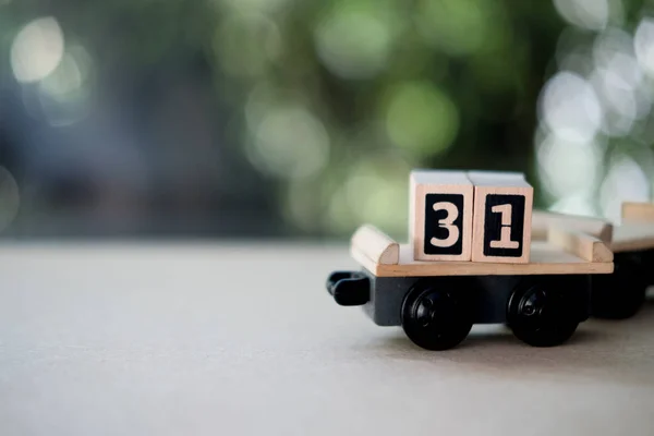Wooden block Day 31 of December month carry on train go to New year. End of month concept