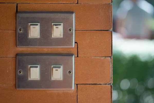 Light switch on orange brick — Stock Photo, Image