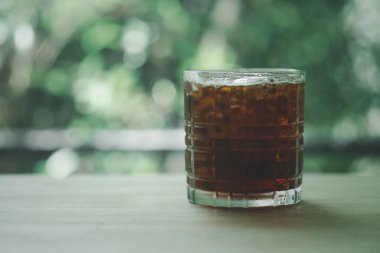 Kafe 'deki masanın üzerinde bir bardak buzlu, siyah kahve.