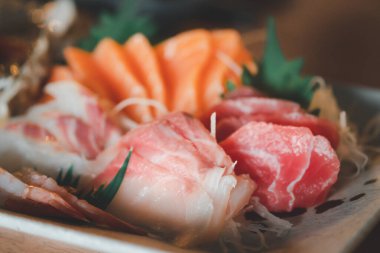 Japon mutfağında taze çiğ somon balığı sashimi dilimlenir. Çeşitli taze sashimi ve Japon yemeği konsepti. Seçici odak