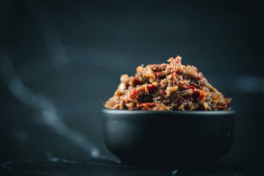 Jaew Bon acı biber ezmesi ya da (Jaew turşulu balık) siyah arka planda siyah kasede. Tayland usulü biber.