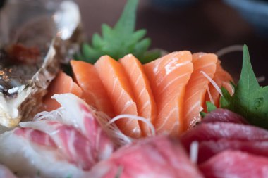 Sashimi karışımı somon ve benzeri şeylerden oluşur. Bir restoranda. Seçici odak