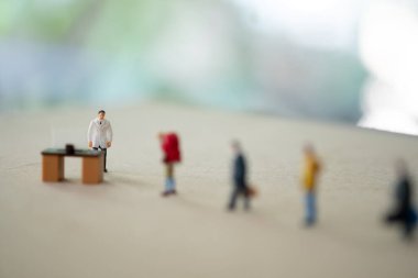 Minyatür yolcu, doktorun kontrol için beklediği virüs hastalık kontrol noktasını bekliyor. Coronavirus konsepti.