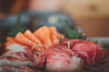 Japon mutfağında taze çiğ somon balığı sashimi dilimlenir. Çeşitli taze sashimi ve Japon yemeği konsepti. Seçici odak