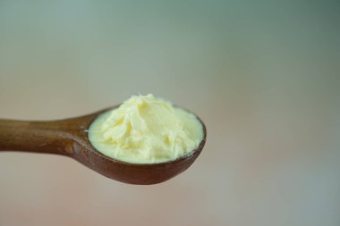 Tahta kaşıkta sarı tereyağı. Kapat.