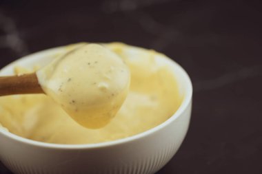 Beyaz kaseden kaşık kaşık dolusu sezar salatası sosu kullan.