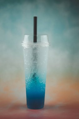 Pastel arka plan için plastik bardakta mavi İtalyan gazozu. Yaz içeceği