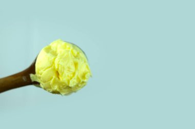 Tahta kaşıkta yumuşak tereyağı. Tahta kaşıkta yumuşak tereyağı. Pişirme malzemesini temsil et. Kapat.