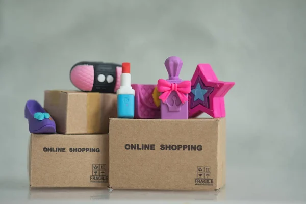 Woman essentials on brown box of shopping online. Concept of shopping online and fast delivery services