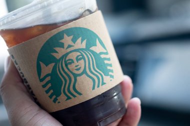 Bangkok, Tayland - 9 Haziran 2020: Starbucks kahvesi kafenin dışında içmek için plastik bardakta çünkü Covid 19 karantinası dükkanda oturamaz, elinde buzlu Americano 'yu kapatamaz.