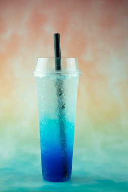 Pastel arka plan için plastik bardakta mavi İtalyan gazozu. Yaz içeceği