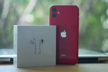 Samut Prakan, Tayland - 18 Haziran 2020: Apple iPhone 11 ProDUCT RED ve Airpod 'lar ahşap masadaki kutuda