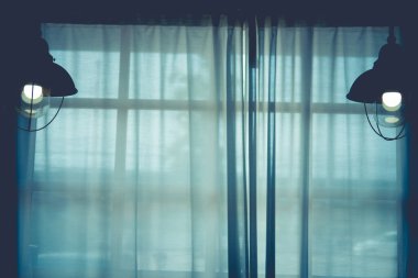 Büyük bir pencere iç görünümünde beyaz şeffaf perdeler