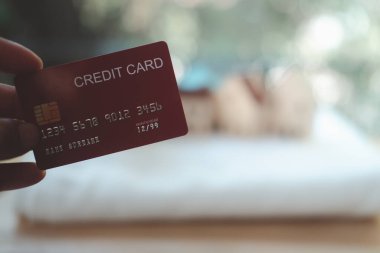 Kırmızı krediyi tutan adamın görüntüsü. Kredi kartıyla ödeme kavramı