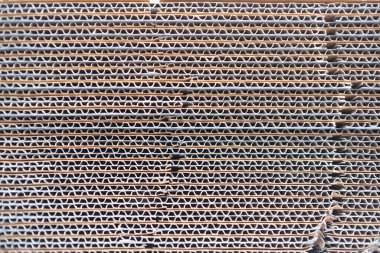 Arkaplanda bükülmüş karton kutu yığını var. Kutunun kenar görünümü