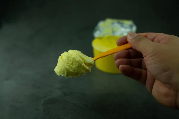 Mantequilla Suave Sobre Una Cuchara Amarilla Sobre Fondo Negro —  Fotos de Stock