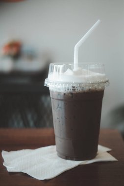 Lezzetli, soğuk, ferahlatıcı kahve mocha koyu çikolata sosunu kağıt mendil üzerine konmuş süt köpüğüyle karıştırın.