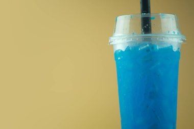 Uzun plastik bardakta buzlu mavi limonlu soda ve siyah pipet. İçecek menüsü için fotoğraf kullan