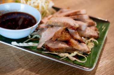 Sos ile servis edilen kömürle kaynatılmış domuz boynu baharatlı ekşi tadı Tayland 'da popüler bir aperatiftir..