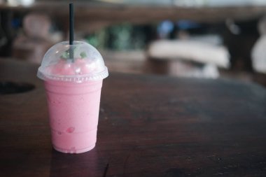 Sağlıklı çilekli yoğurt. Ahşap masadaki plastik camda.