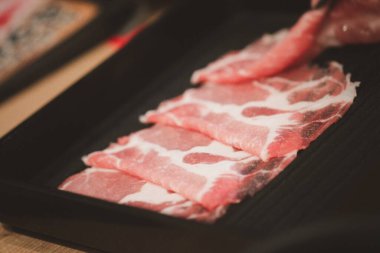 Shabu Shabu için hazırlanmış dilimlenmiş siyah Wagyu et tepsisini kapat.