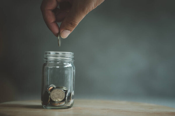Рука положила монету в стеклянную бутылку. Концепция финансов, экономики и сбережения денег
.