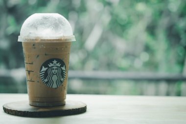 Bangkok, Tayland - 14 Temmuz 2020 Starbucks kahve dükkanının ahşap masasındaki paket camında buzlu mocha