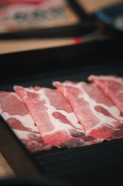 Shabu Shabu için hazırlanmış dilimlenmiş siyah Wagyu et tepsisini kapat.