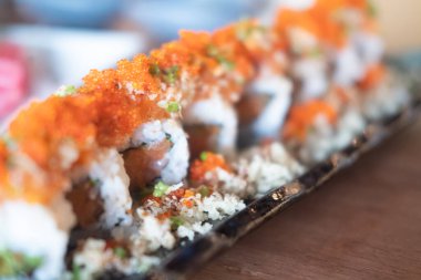 Kaliforniya dürümü taze somon ve somon yumurtası ile kaplı ve çıtır karides ile servis ediliyor. Seçici odak