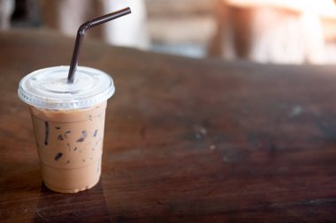 Ahşap masada plastik bardakta buzlu Mocha kahvesi.