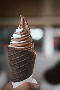 Çikolata külahında karışık kremalı el ele tutuşmak.