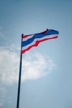Mavi gökyüzünde Tayland bayrağı ve açık alanda beyaz bulut