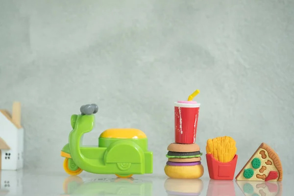 Close up of miniature motorcycle toy and fast food for delivery to home. Couriers carry out orders for the delivery of food