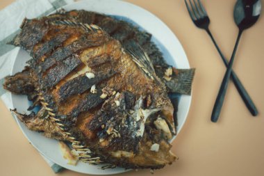Kızarmış Tilapia balığı, tabakta kızartıldıktan sonra yemeye hazır. Tayland usulü ev yemeği kavramı