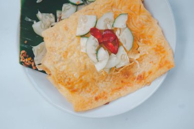 Vietnam usulü çıtır yumurtalı krep. Birçok sebzeden yapılan yerel tatlı. Karides, tofu, fıstık ve krep gibi yumurtayla sarılmış.