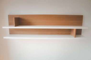 Dairenin beyaz duvarına boş ahşap raflar süslemesi