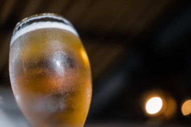 Soğuk zanaat hafif birasını su damlalarıyla dolu bir bardakta kapat..