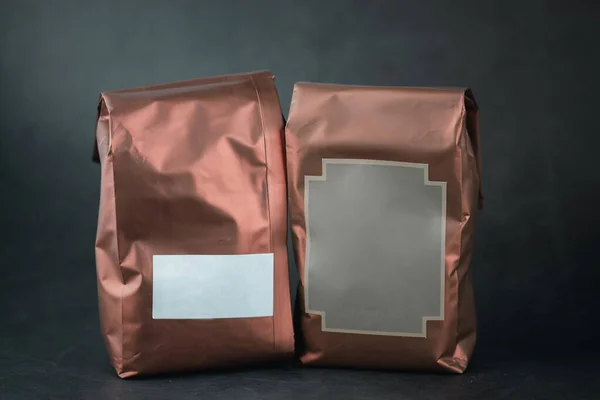 Aluminium foil copper color bags for cocoa powder or coffee beans on black background