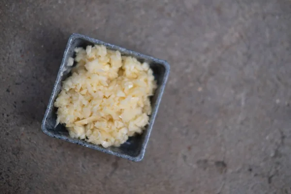 Bawang Putih Cincang Halus Dalam Mangkuk Persegi Latar Belakang Batu — Stok Foto